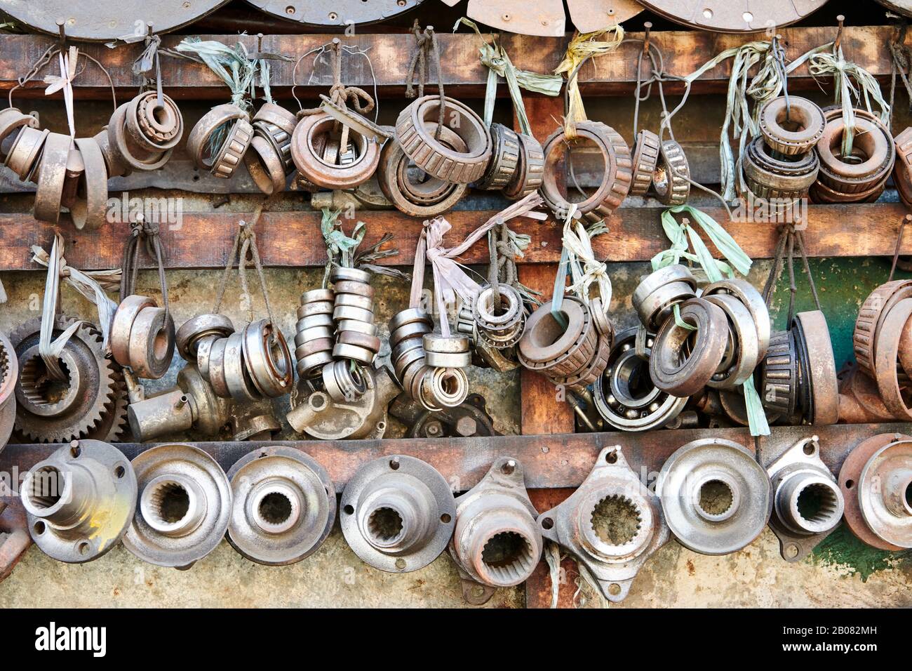 Close-up of an array of used rusty old bearings and other car parts hanging in line in a auto junk shop in Iloilo City, Philippines, Asia Stock Photo