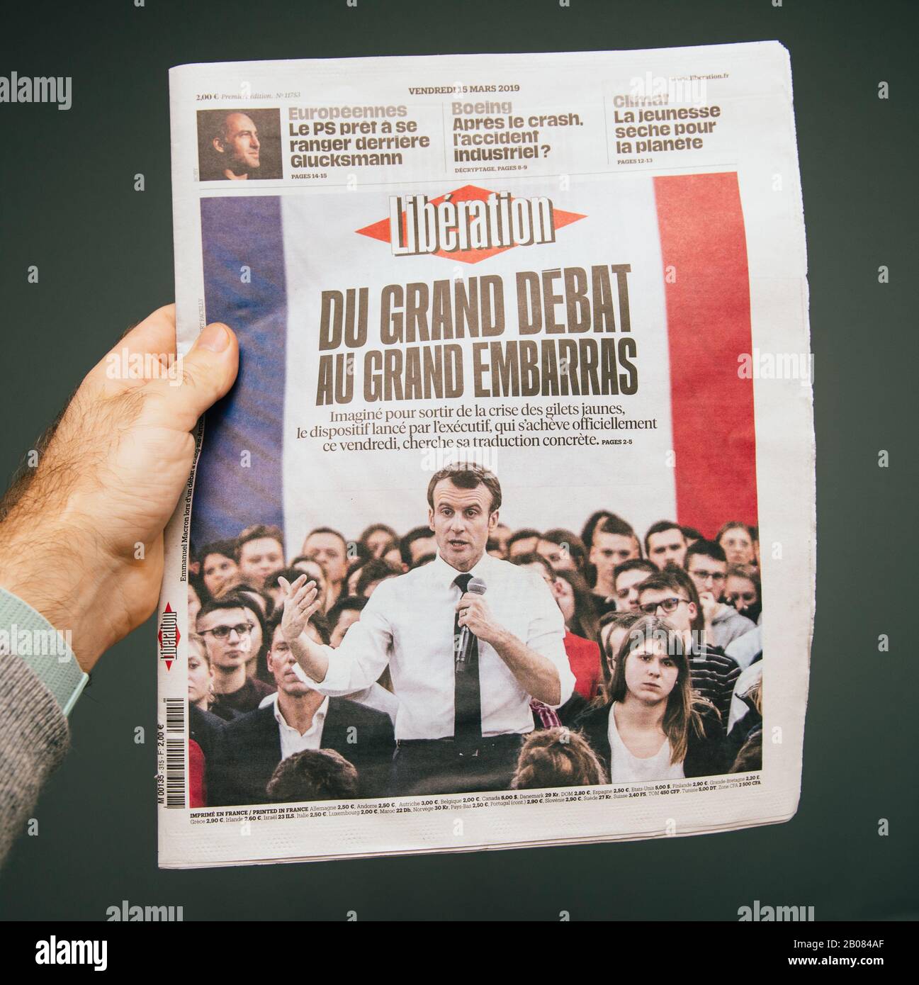 Paris, France - Mar 15, 2019: Male hand POV at the latest Liberation edition of newspaper featuring Emmanuel macron grand debat breaking news Stock Photo