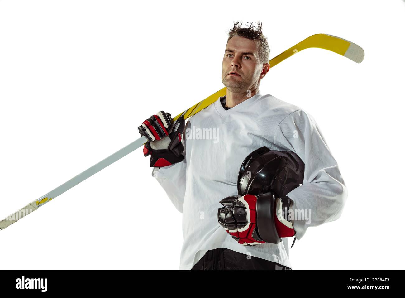 Champion. Young male hockey player with the stick on ice court and white background. Sportsman
