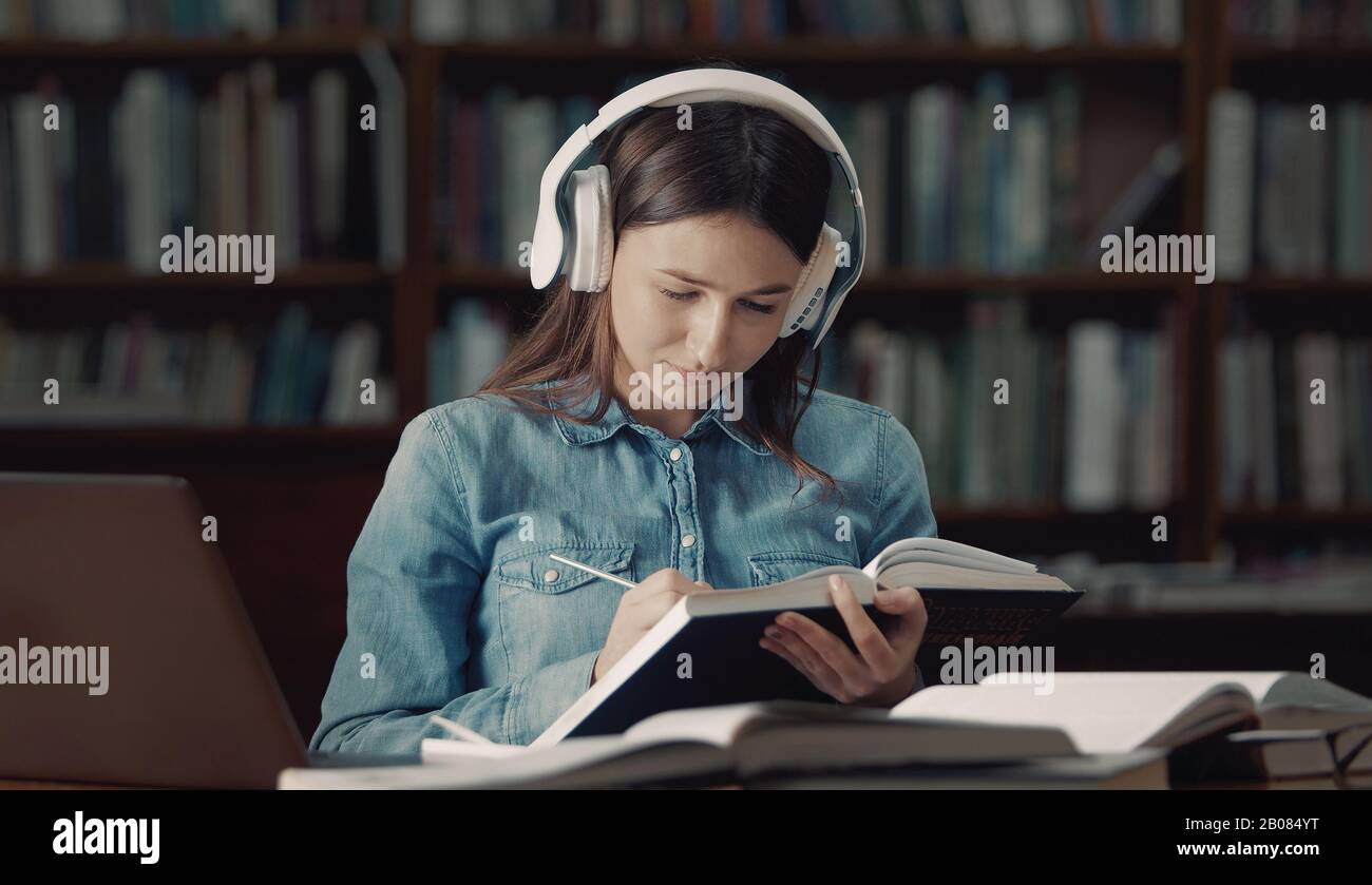 Student listens audiolesson in library Stock Photo - Alamy