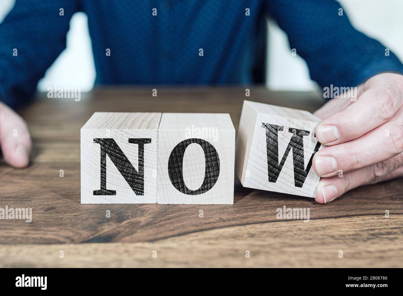 hand arranging wooden blocks with word NOW, call to action concept Stock Photo