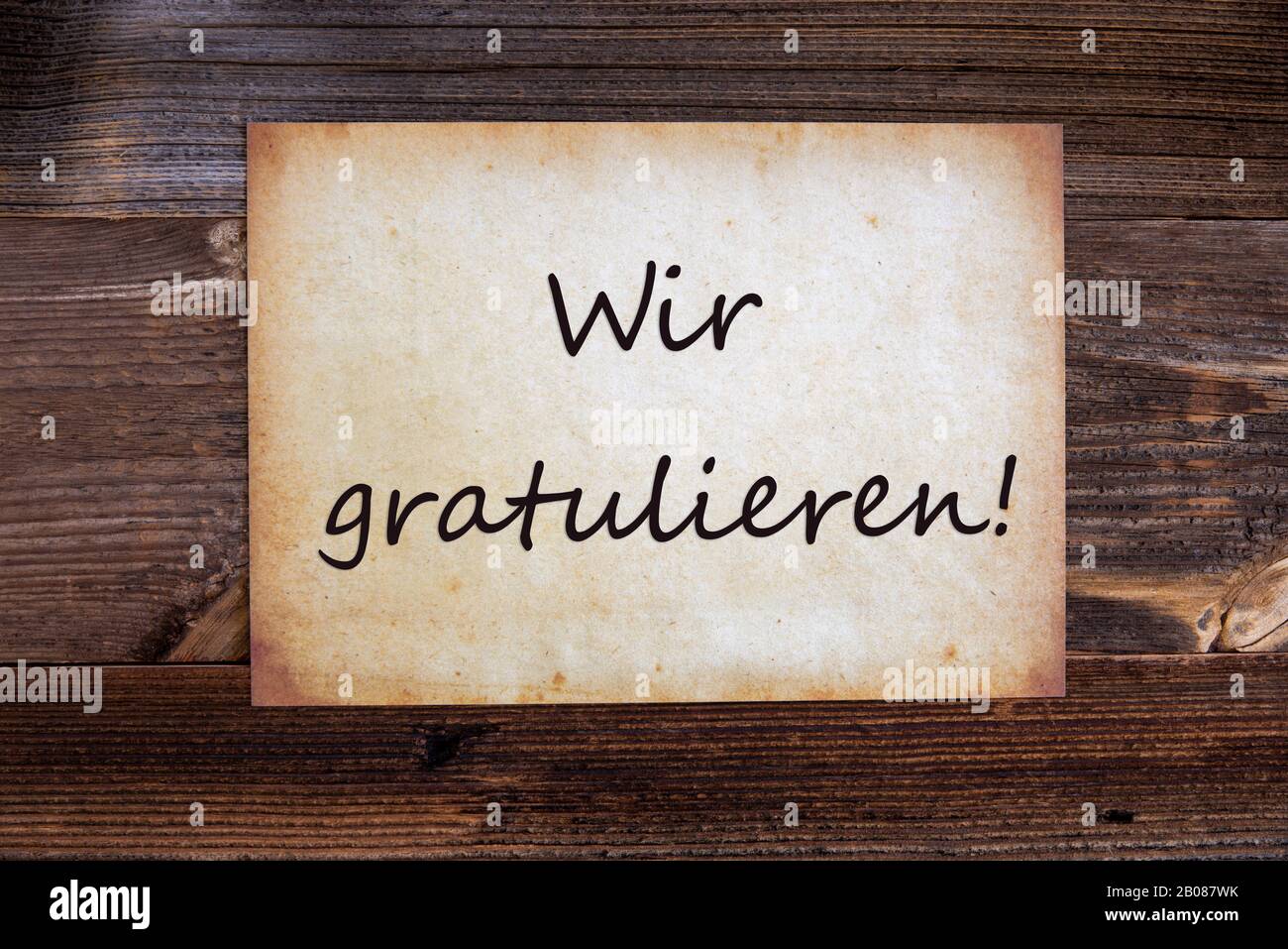 Old Paper, Wir Gratulieren Means Congratulations, Wooden Background Stock Photo
