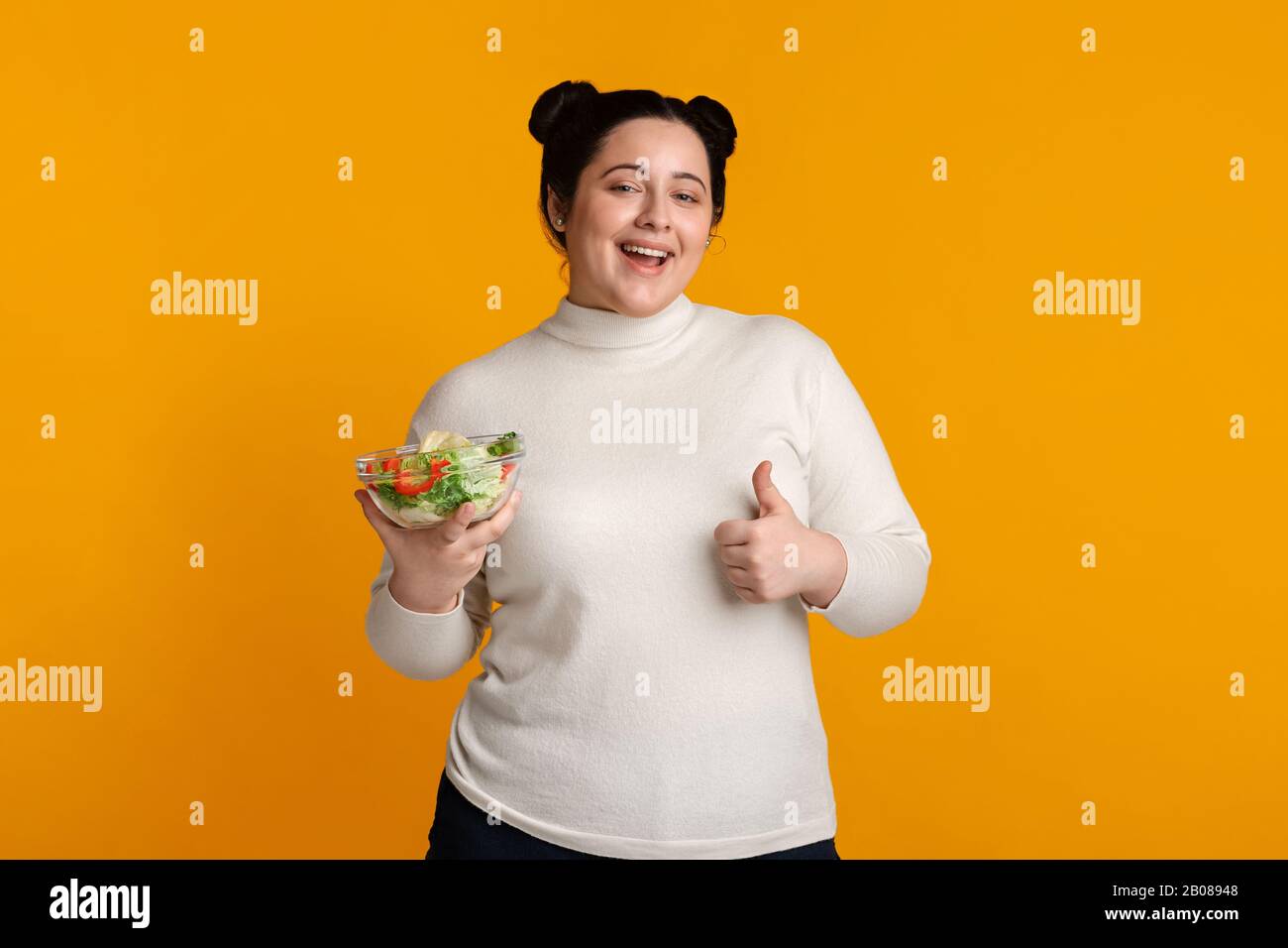 Happy Overweight Girl Holding Bowl With Salad And Showing Thumb Up Stock Photo