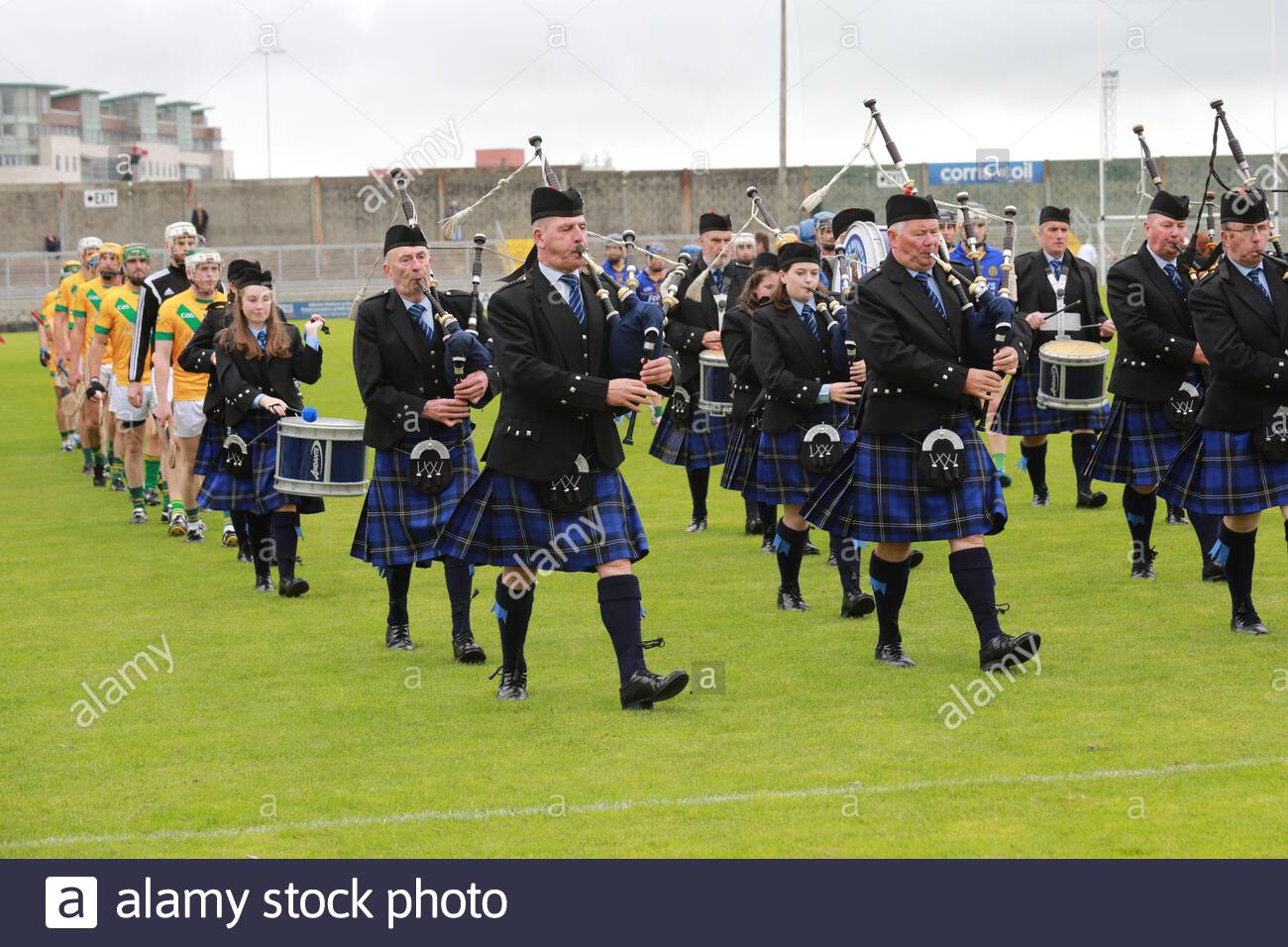 A pipe band leads the two teams around the field at the start of a County Kerry Club Hurling final Stock Photo
