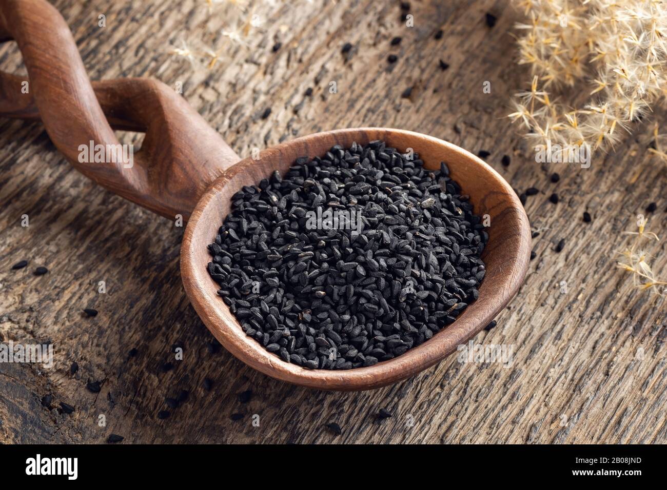 Black cumin, or Nigella sativa seeds on a wooden spoon on a table Stock Photo