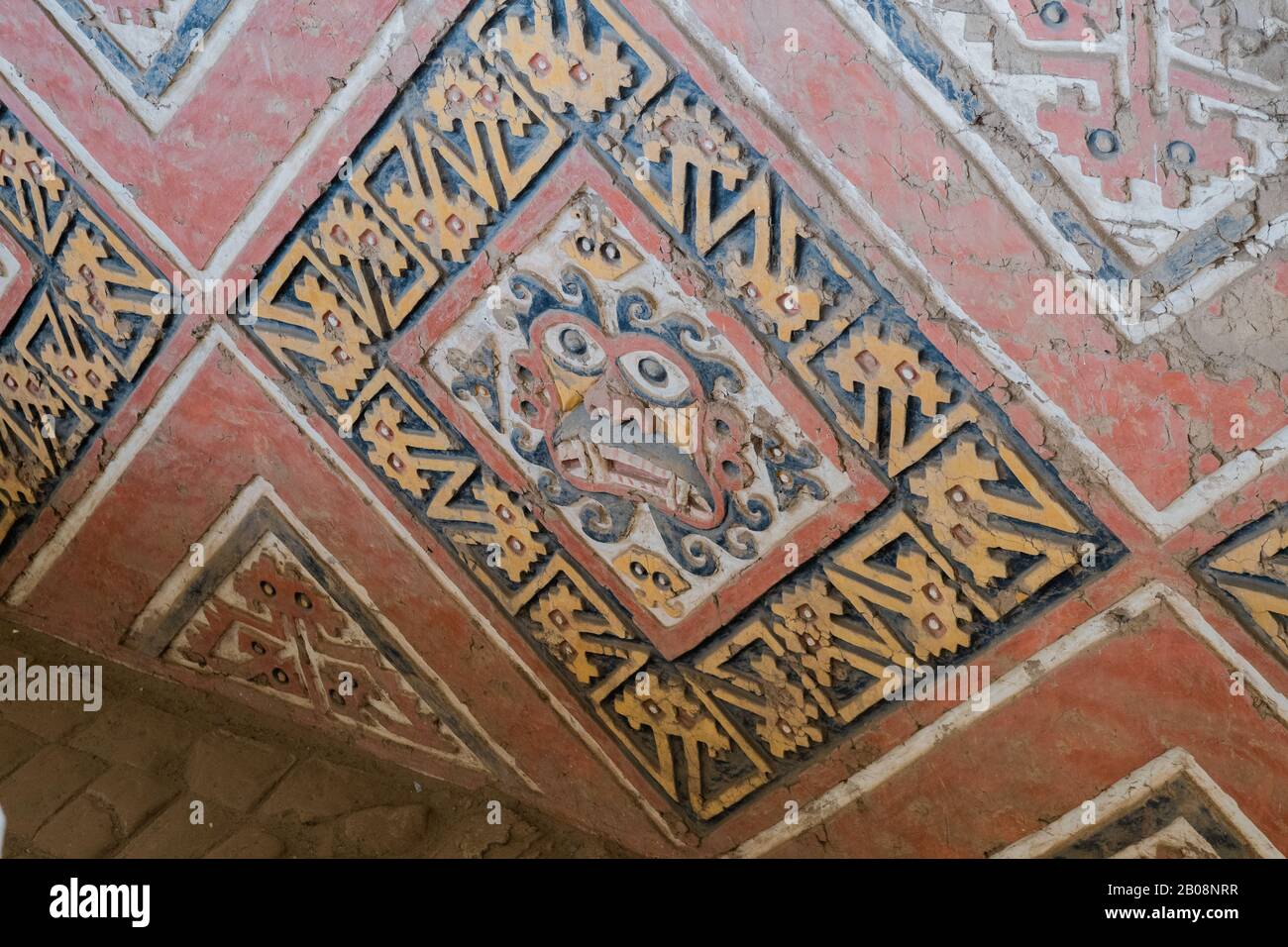 Painted and carved reliefs of the god Ayapec from the pre-Incan Mochican culture on the adobe walls of the Huaca de la Luna near Trujillo, Peru Stock Photo