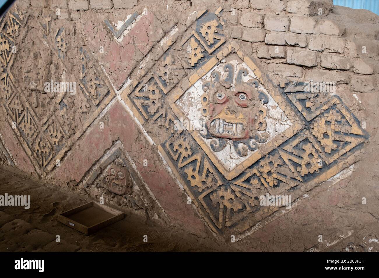 Painted and carved reliefs of the god Ayapec from the pre-Incan Mochican culture on the adobe walls of the Huaca de la Luna near Trujillo, Peru Stock Photo