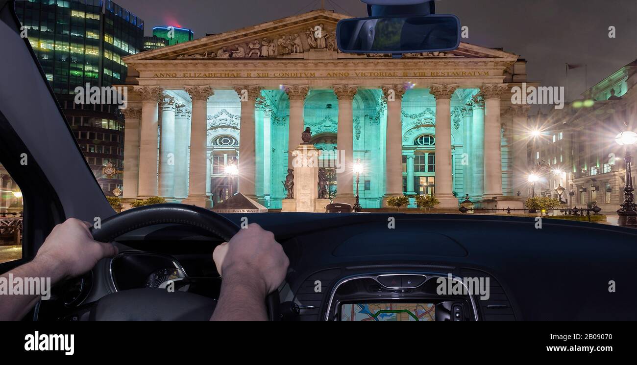 Driving a car at night towards the Royal Exchange Building, iconic landmark in London, UK Stock Photo