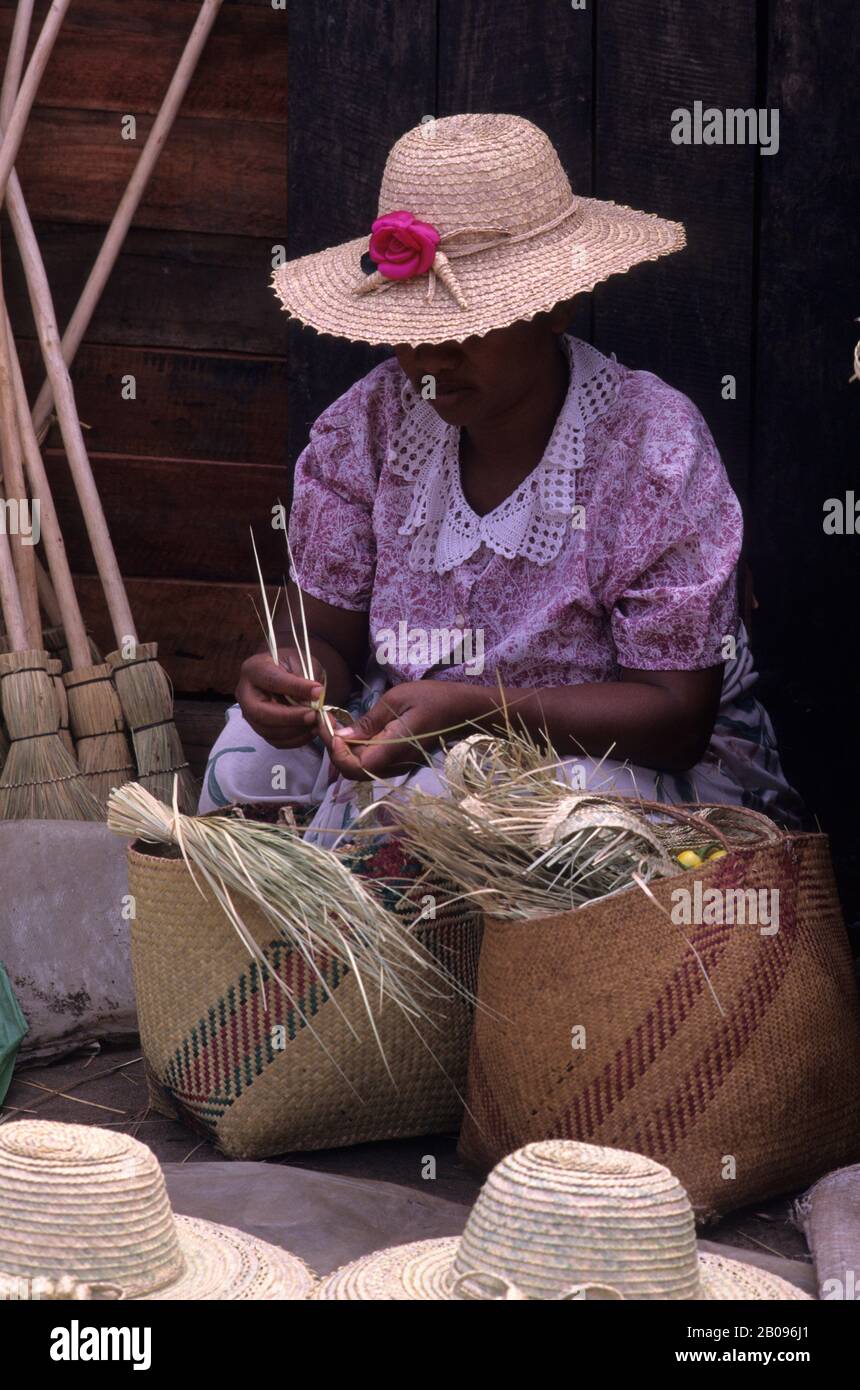 MADAGASCAR, MANANJARY, MARKET SCENE, WOMAN MAKING STRAW HATS Stock Photo