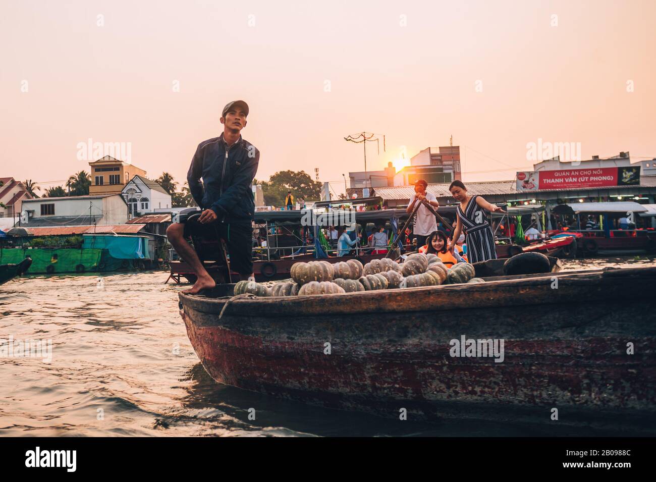 A local Vietnamese man on his boat at sunrise looking out at the ...