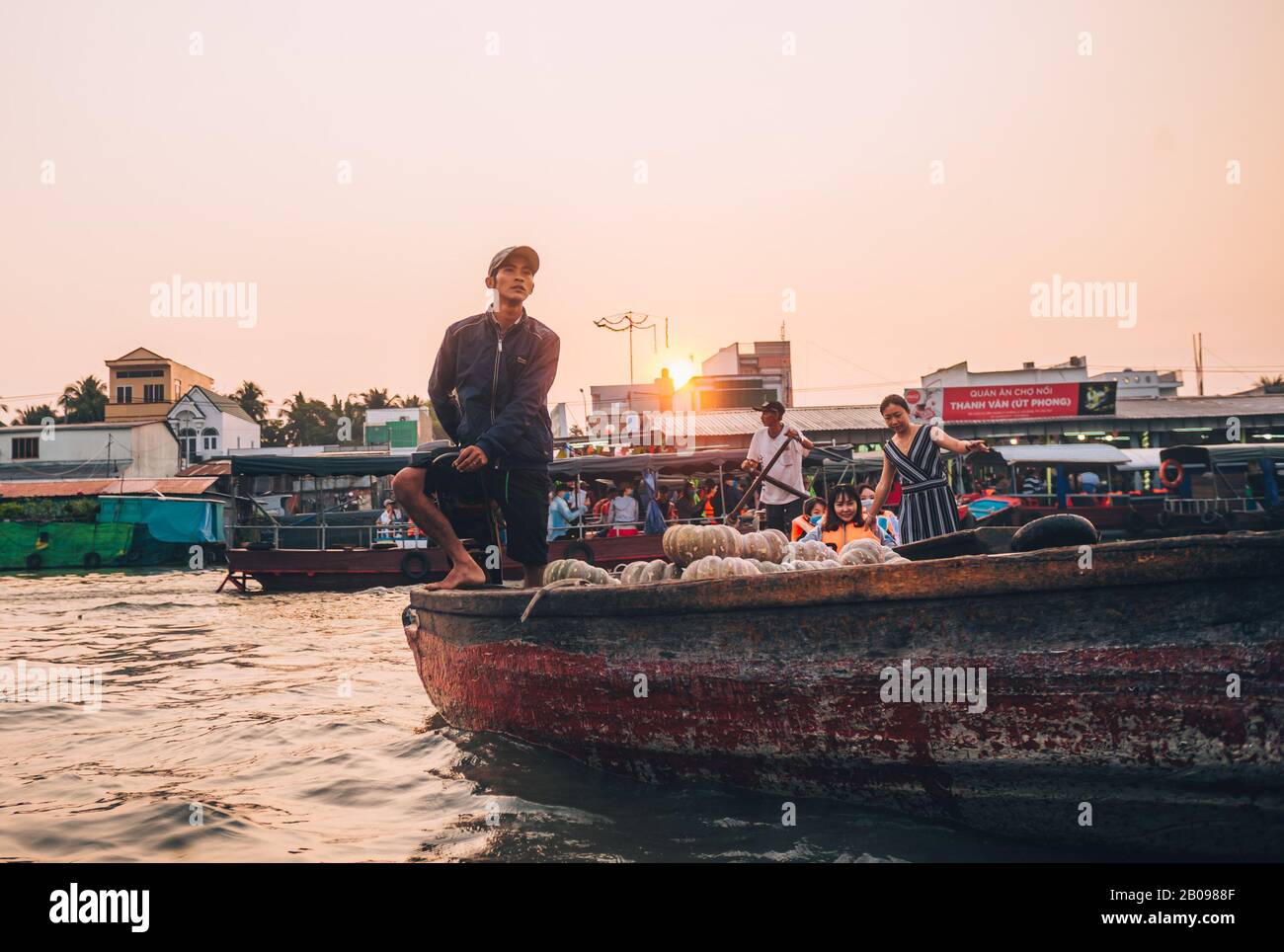 A local Vietnamese man on his boat at sunrise looking out at the ...