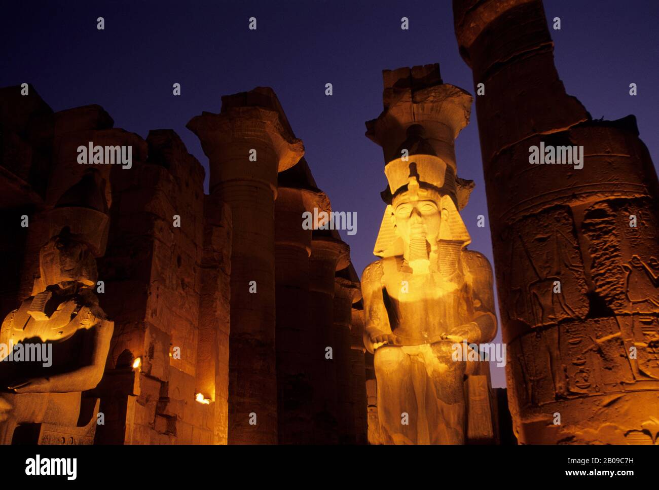EGYPT, NILE RIVER, LUXOR, TEMPLE OF LUXOR, STATUE OF RAMSES II AT ENTRANCE TO GREAT COLONNADE Stock Photo