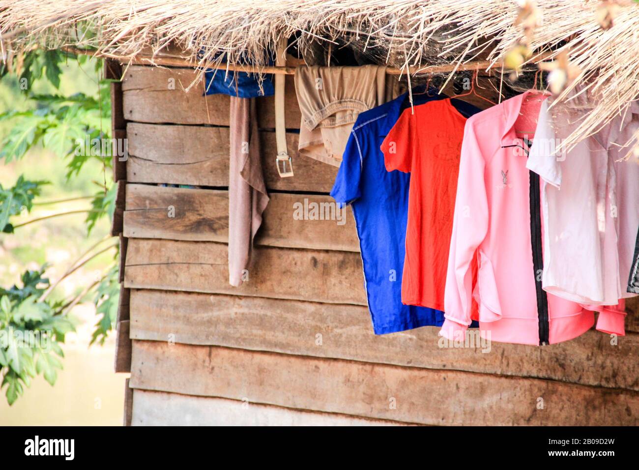 Shirts and other clothes drying on the rope outside of a wooden cottage Stock Photo Alamy