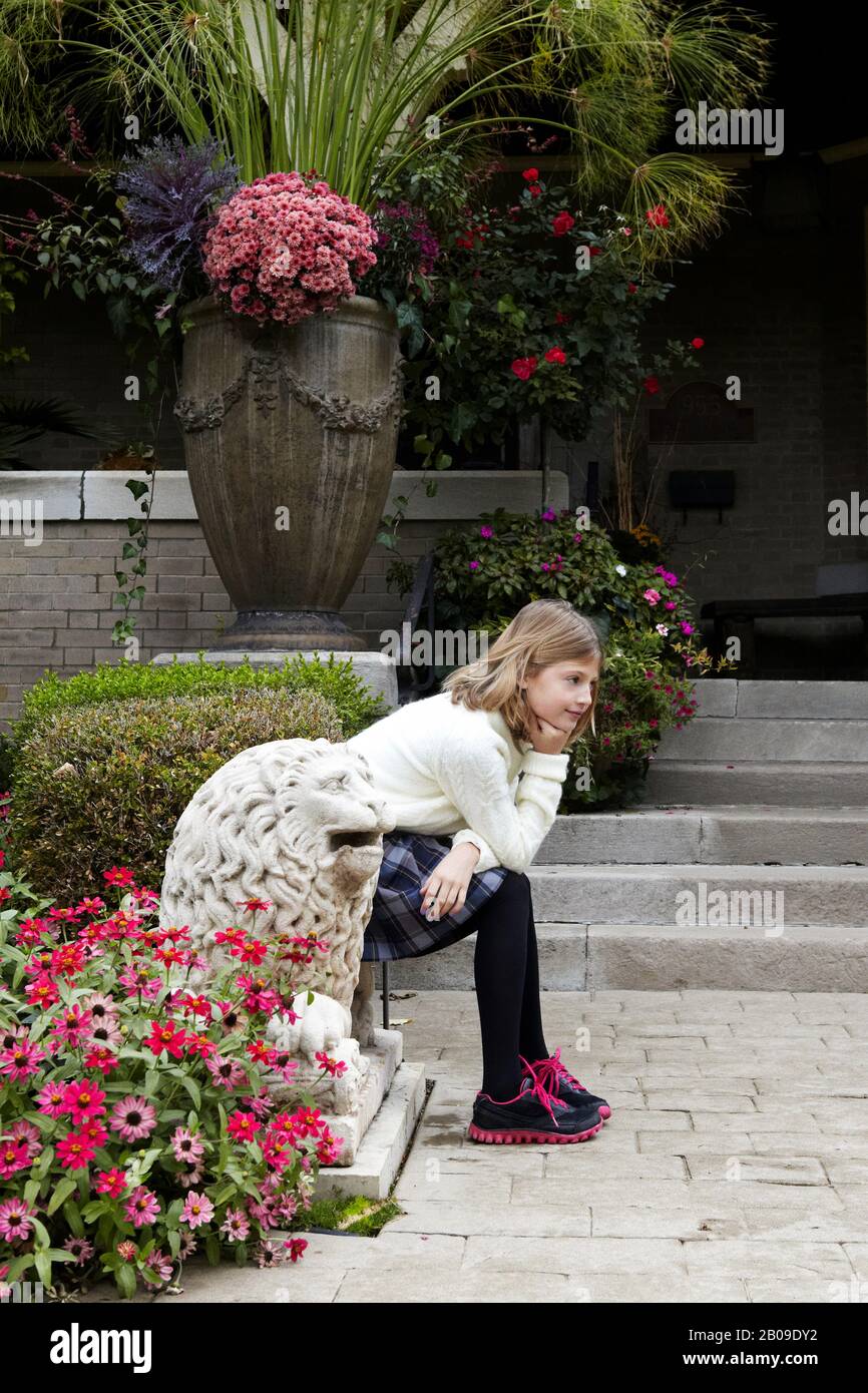 10 year old girl in garden after school wearing uniform Stock Photo