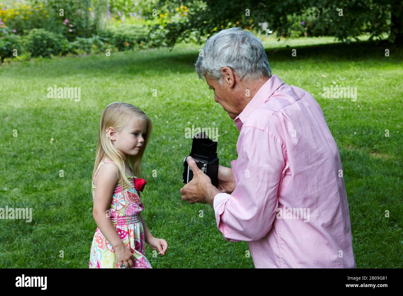 grand father and grand children playing in Park Stock Photo