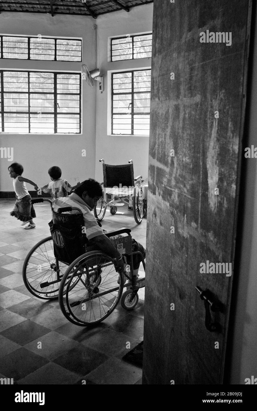 Prabhu, one of the children with Cerebral Palsy, waits at the entrance to the toilet for the caregiver to take him there. Parents Association of Persons with Cerebral Palsy and Associated Disorders (PAPCP) in Bangalore, India. January 22, 2009. One of a set of images from the photo story Cerebral Palsy, by Ayush Ranka. Stock Photo
