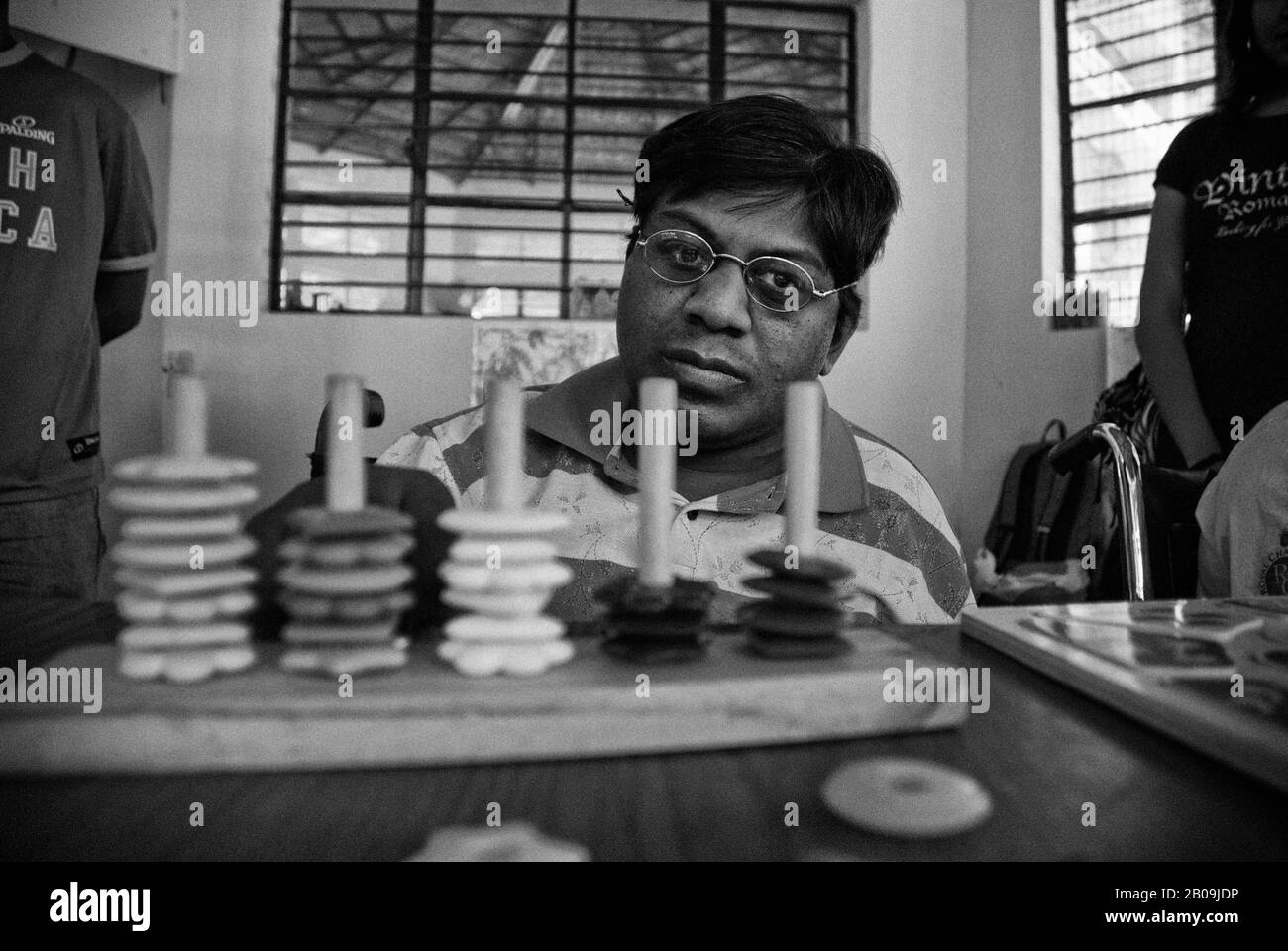 Prabhu, one of the children with Cerebral Palsy tries to do simple math with an abacus, at the Parents Association of Persons with Cerebral Palsy and Associated Disorders (PAPCP). He is mostly at peace with himself and is very friendly. Bangalore, India. January 21, 2009. One of a set of images from the photo story Cerebral Palsy, by Ayush Ranka. Stock Photo