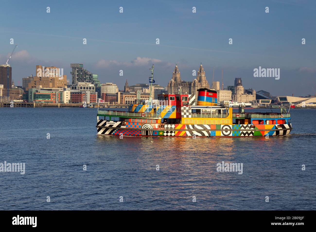 M.V. Snowdrop, Mersey ferry in Dazzle livery designed by Sir Peter Blake, against the Liverpool city skyline. Stock Photo