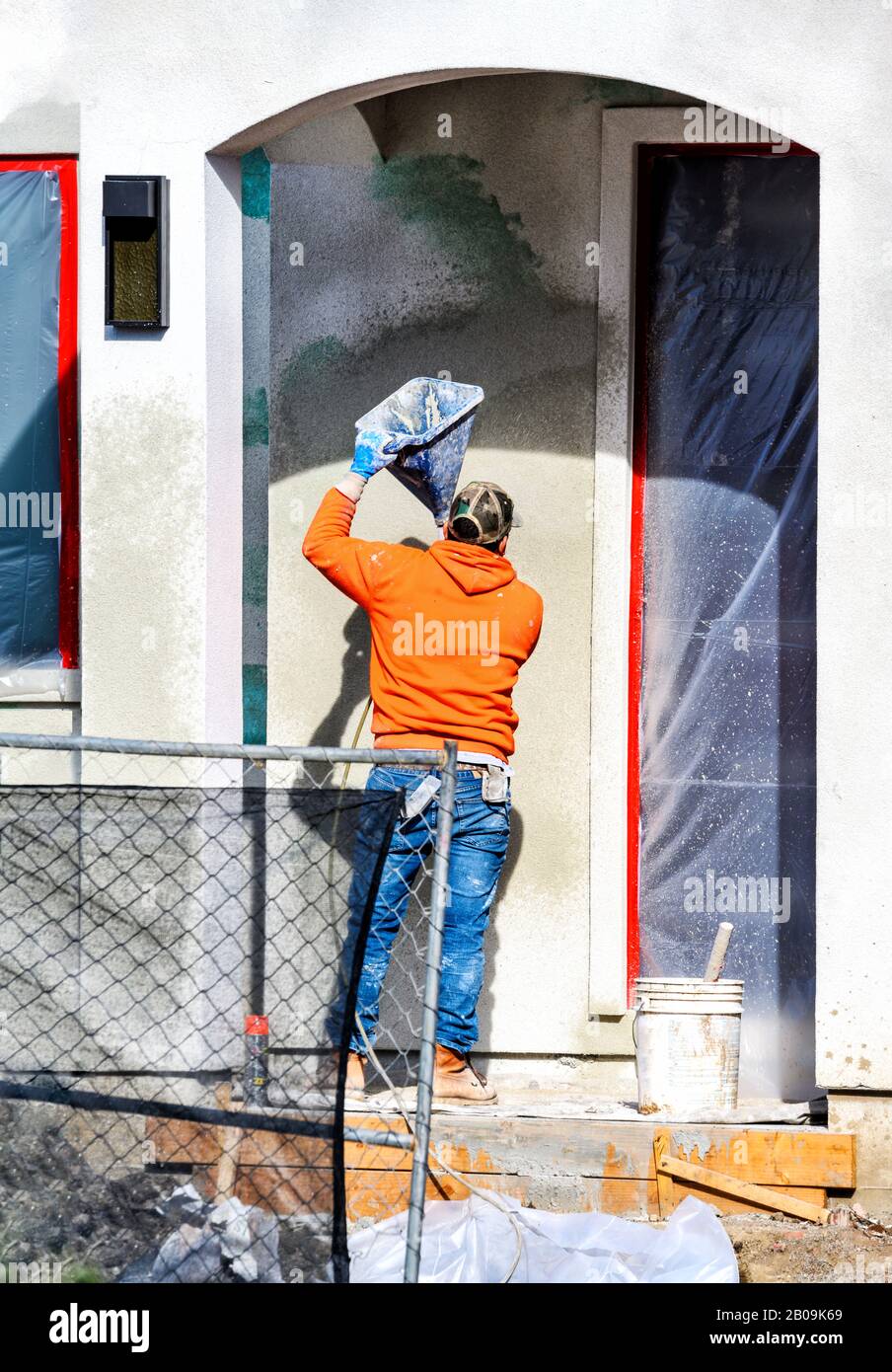 Construction worker putting decorative plaster on house exterior Stock Photo