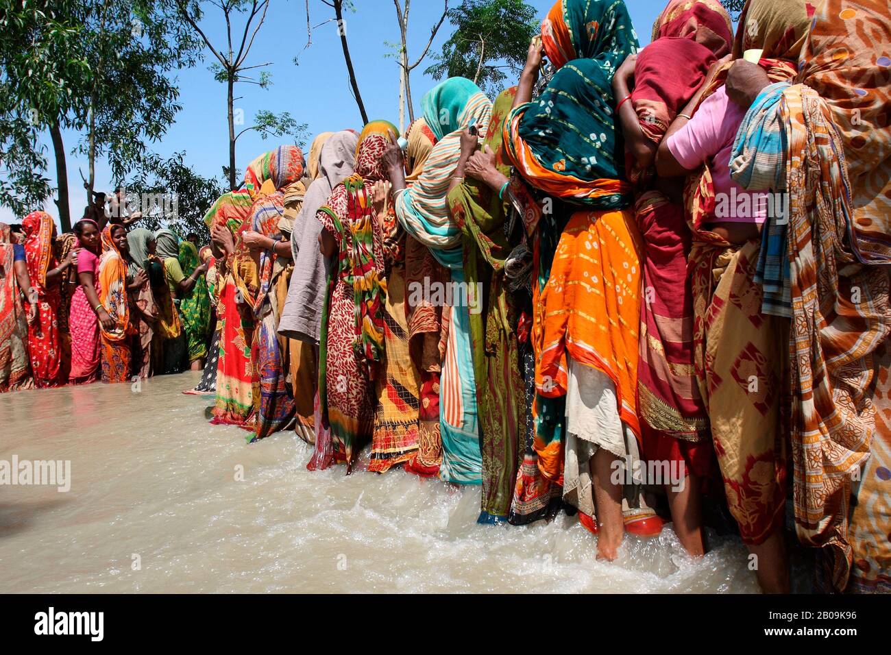Women stand in lines to collect relief from a flood relief center in Sirajganj. Nearly 0.7 million people of the northern district have been affected by the severe flood of 2007. Sirajganj, Bangladesh. August 3, 2007. Stock Photo