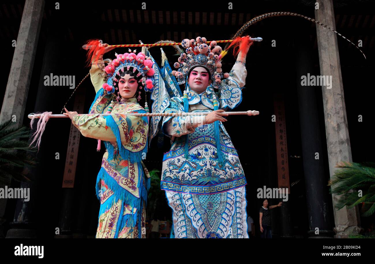 A man and a woman perform a traditional Chinese dance at a temple in Guangzhou Province, China. September 17, 2009. Stock Photo