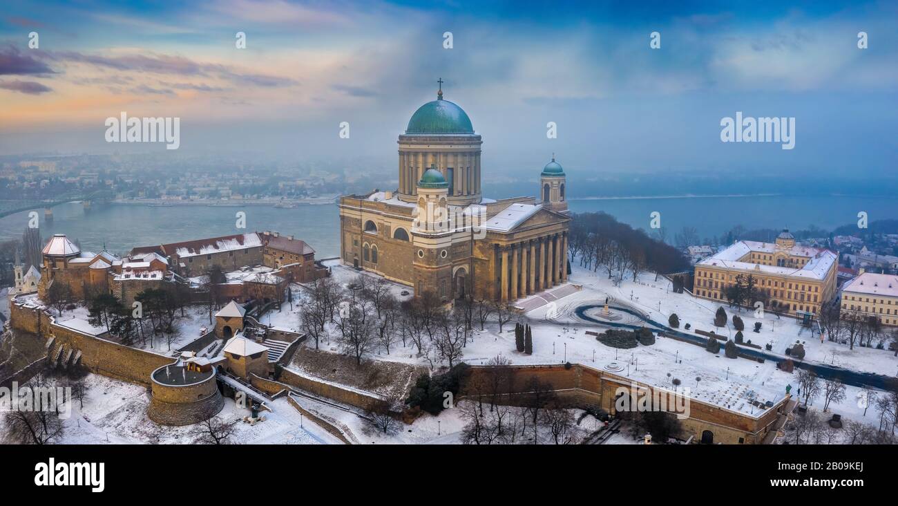 Esztergom, Hungary - Aerial panoramic view of the beautiful snowy Basilica of Esztergom with Slovakia at the background on a foggy winter morning Stock Photo