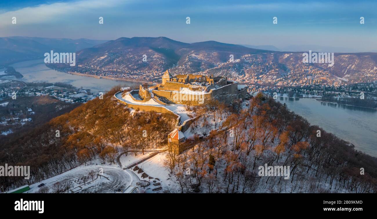 Visegrad, Hungary - Aerial panoramic view of the beautiful snowy high castle of Visegrad at sunrise on a winter morning with Dunakanyar at background Stock Photo