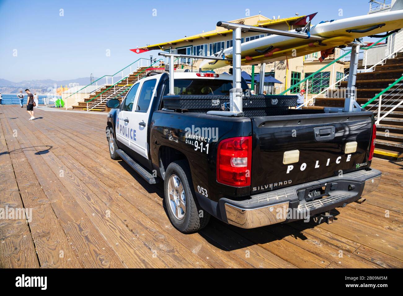 Chevrolet Silverado Hybrid police patrol pickup with surfboard, on the end of Santa Monica pier. California, United States of America Stock Photo