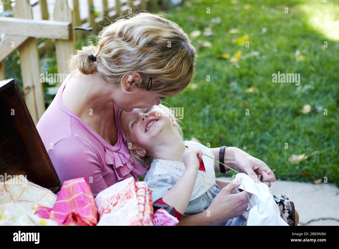 mother and daughter sewing and laughing Stock Photo