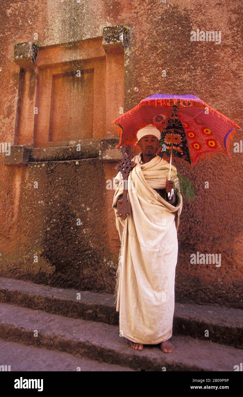 ETHIOPIA, LALIBELA, UNESCO WORLD HERITAGE SITE,  CHURCH CARVED INTO ROCK, PRIEST WITH CROSS Stock Photo
