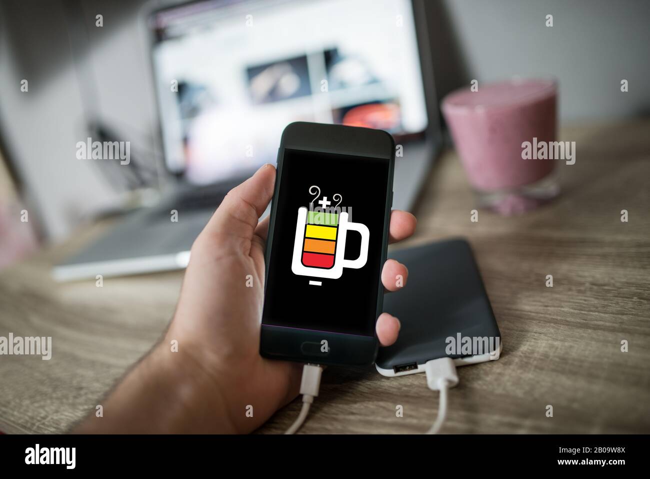 Man holding mobile phone in his hand that is charging with power bank