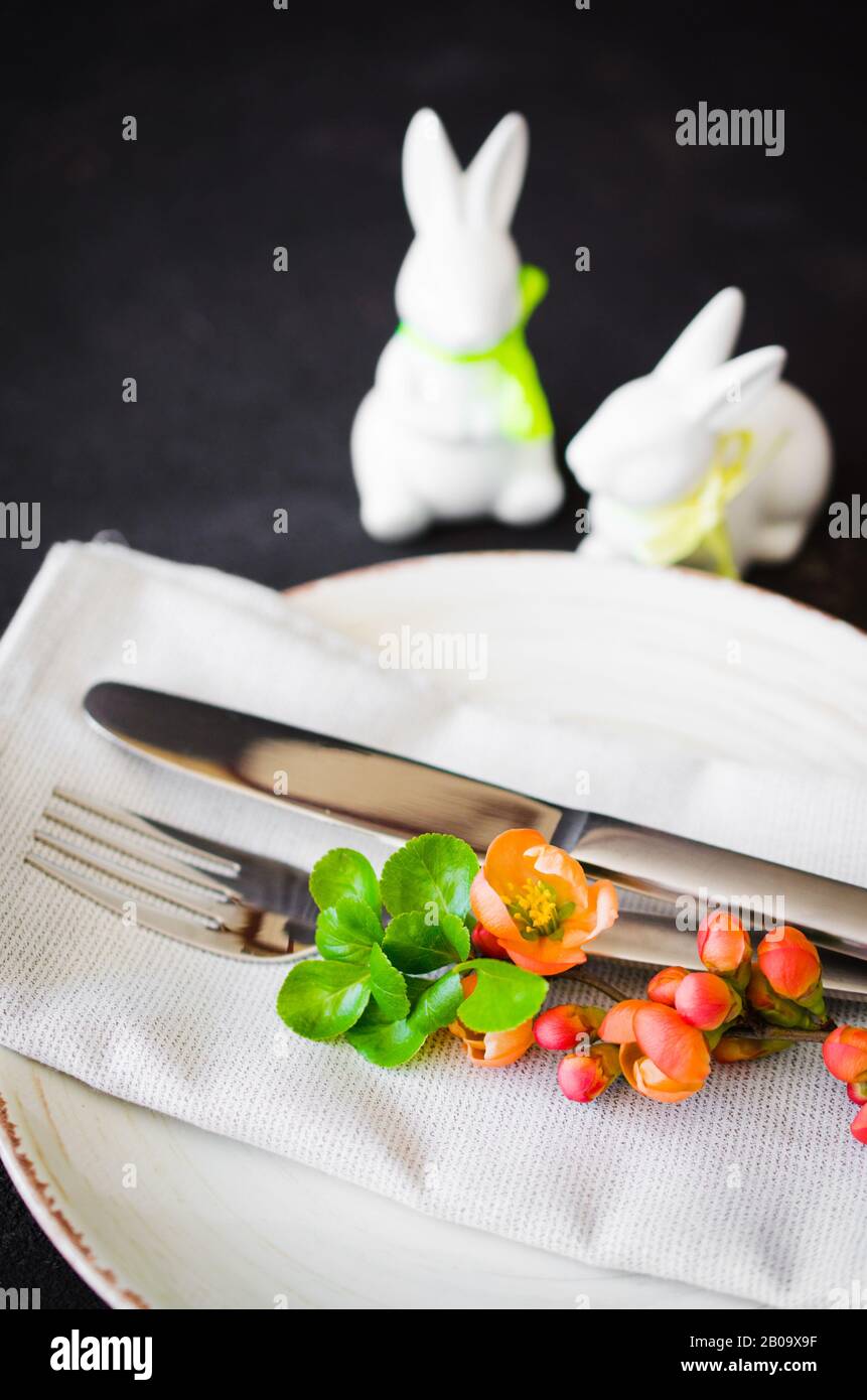 Easter table setting with spring flowering branches, cutlery and ...