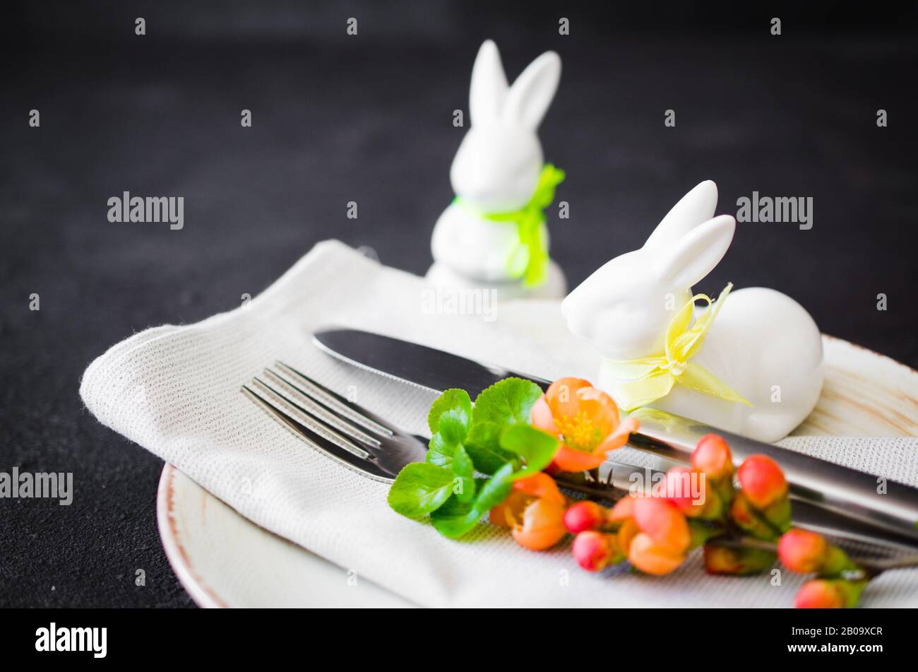 Easter table setting with spring flowering branches, cutlery and ...