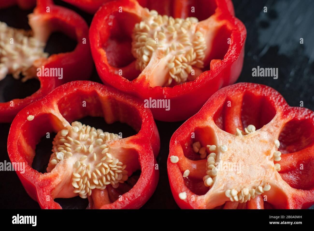 Sliced Red sweet pepper on a dark background. Fresh whole red bell