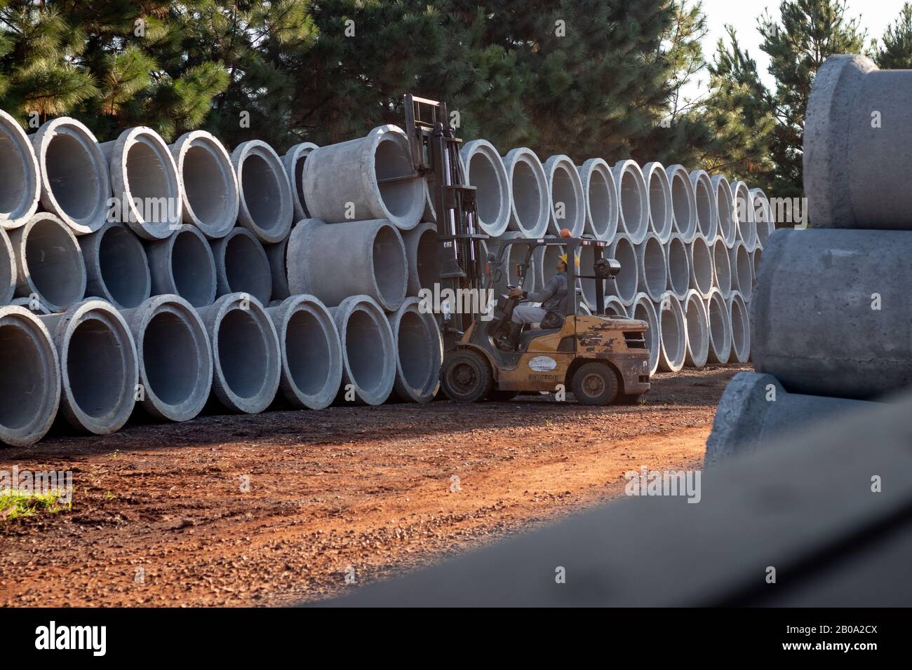 A forklift carrying sewer pipes Stock Photo