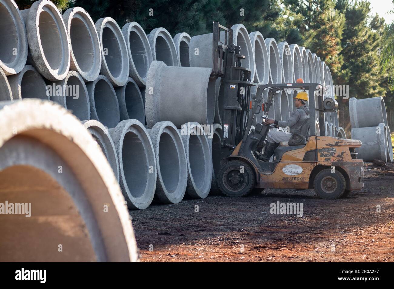 A forklift carrying sewer pipes Stock Photo