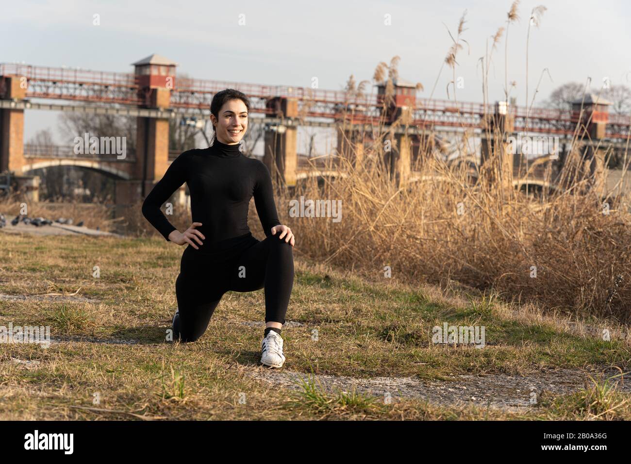 Portrait of sports girl doing yoga stretching exercise on the riverside Stock Photo