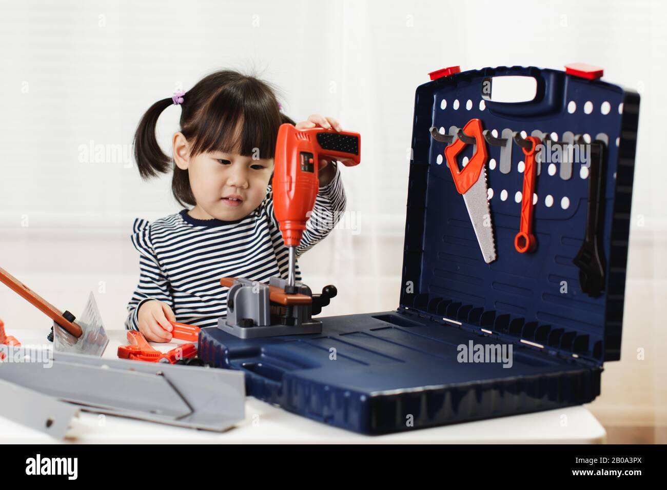 toddler girl pretend using DIY tool at home against white background ...