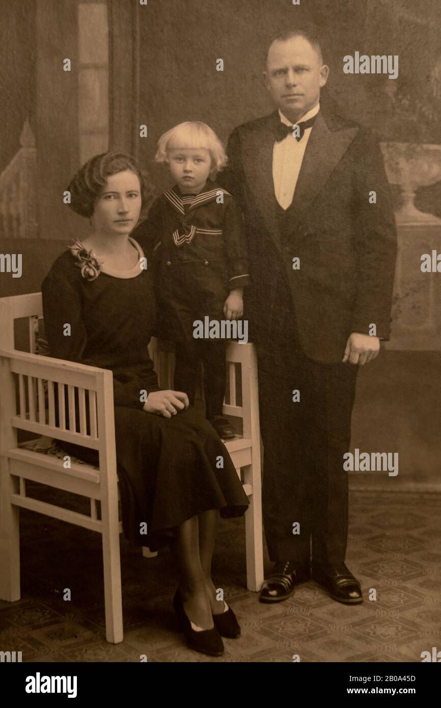 LATVIA- CIRCA 1925- 1930: Shot of married couple and their child in studio, Vintage Carte de Viste Art Deco era photo Stock Photo