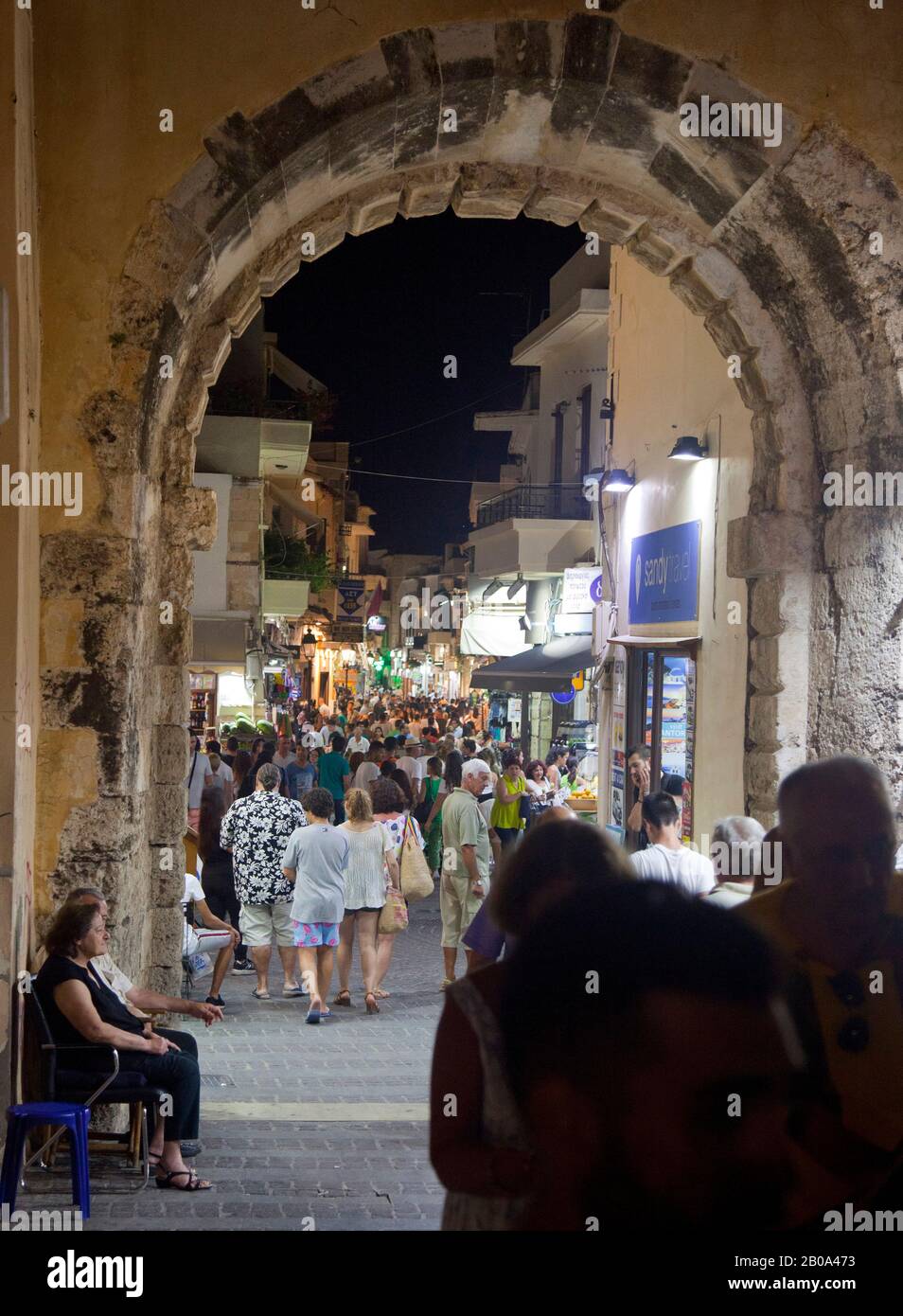 Tourists walk along the narrow streets of the old town of Rethymno ( Rethimno ) at night time. The city is located on the north coast of Crete. August Stock Photo