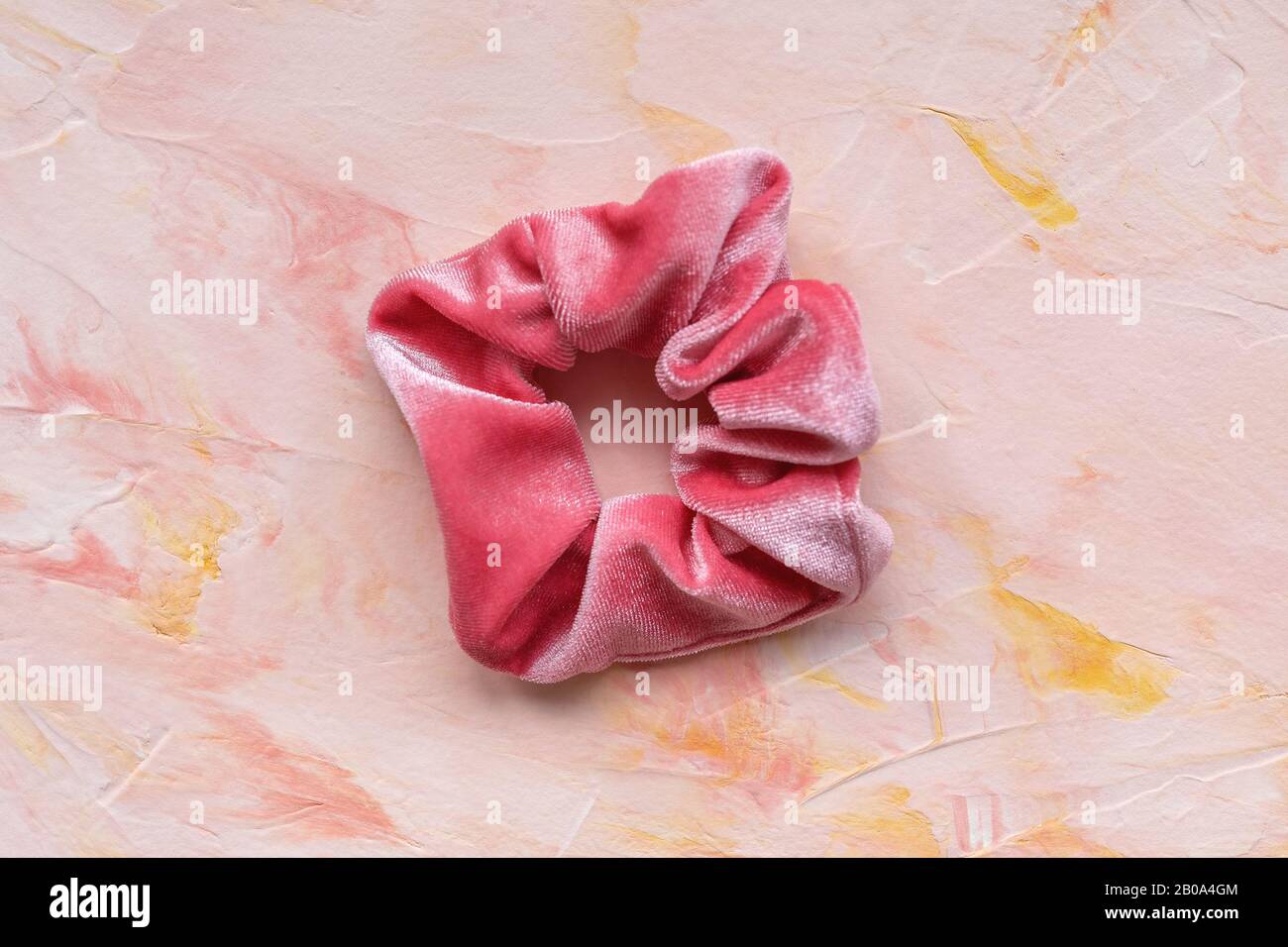 One pink trendy velvet scrunchie on pastel background. Diy accessories and hairstyles concept, copy space Stock Photo