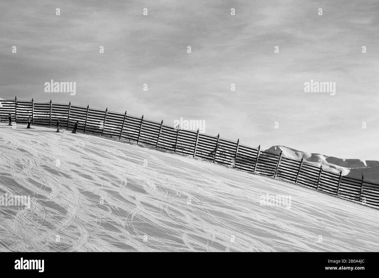 Snowy ski track prepared by snowcat with trace from skis and snowboards. High mountains at sunny winter day. Italian Alps. Livigno, region of Lombardy Stock Photo