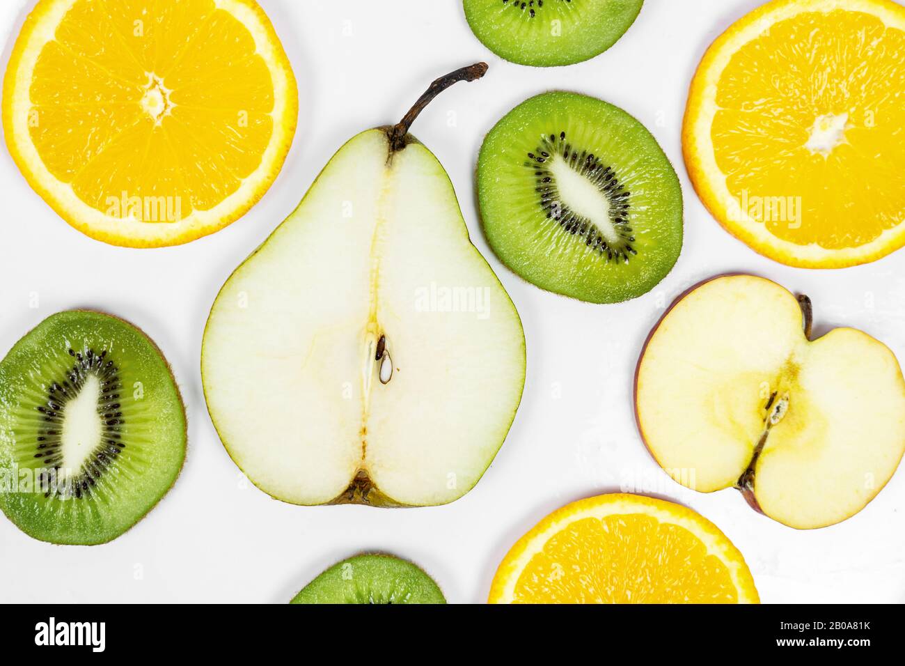 close up sliced fresh colorful fruits pear kiwi orange apple on a white background . Stock Photo