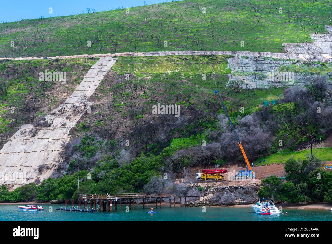 Knysna Lagoon, Mossel Bay, South Africa -- January 9, 2018. Workmen and construction equipment on the side of Outeniquas Mountains. Stock Photo