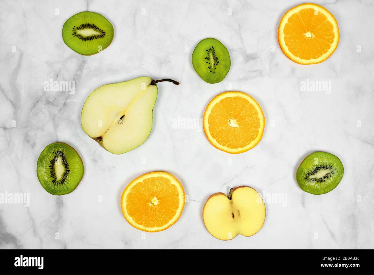 sliced fruits pear kiwi orange apple with minimalist marble background . Stock Photo
