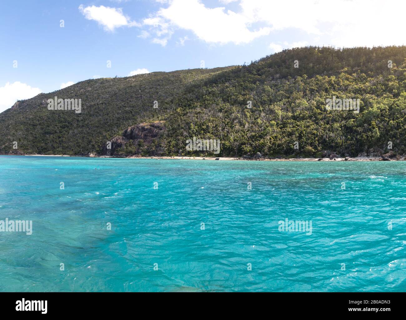 Turquoise waters and green island of the Withsundays during sunny day Stock Photo