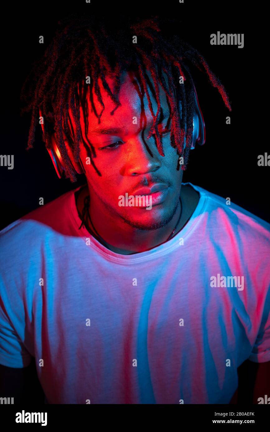 Portraits of beautiful African young man under blu and red lights Stock Photo