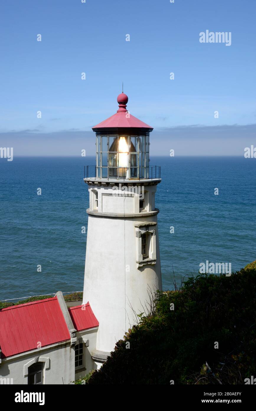 Heceta Head Lighthouse on a sunny day with pacific ocean background. Stock Photo