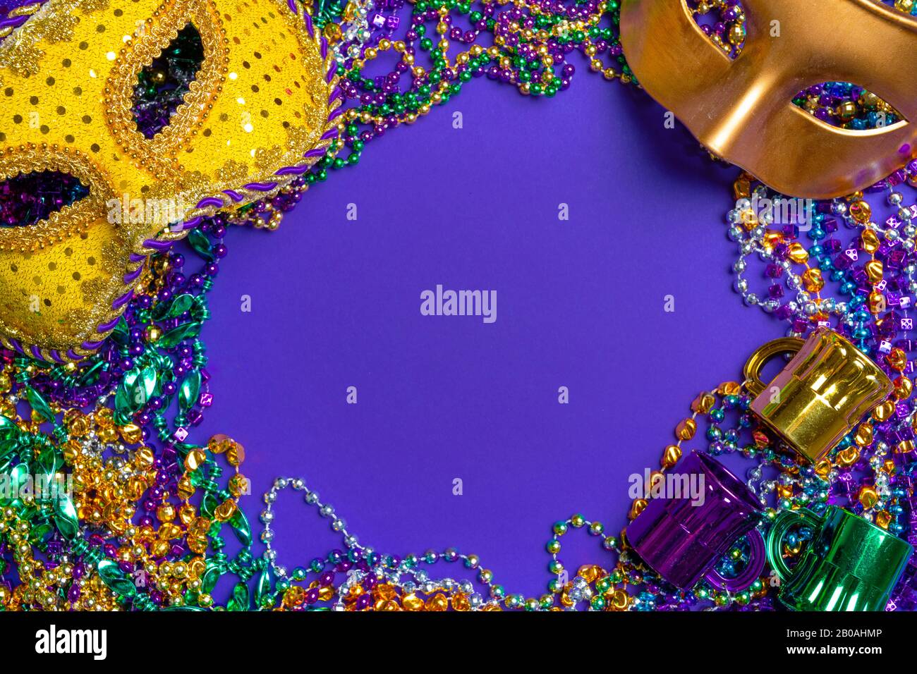 Colorful Mardi Gras mask on purple background with beads Stock Photo