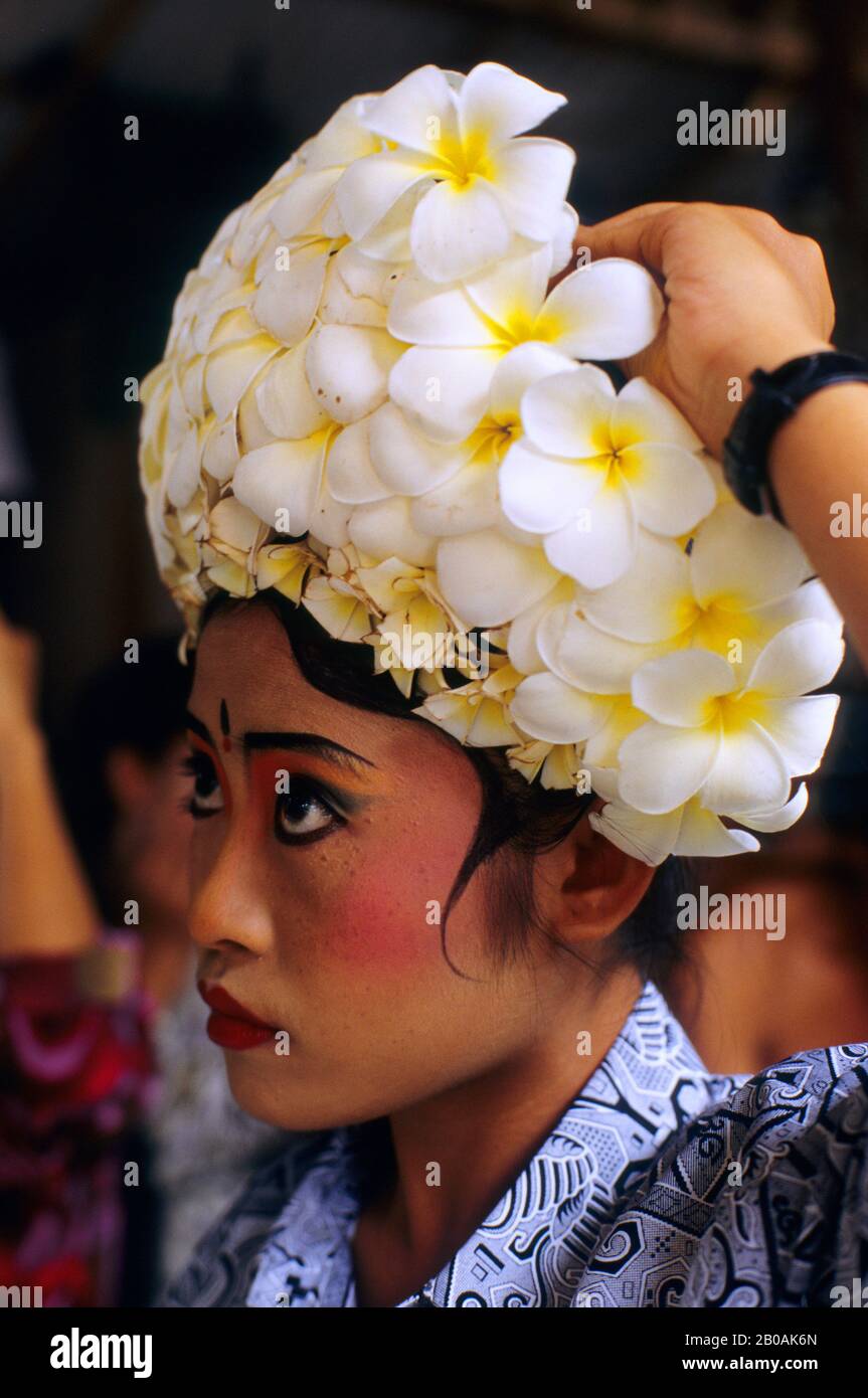 INDONESIA, BALI, BARONG DANCE, DANCER PREPARING COSTUME, FRANGIPANI FLOWERS Stock Photo
